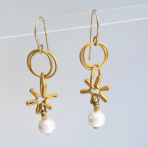 Earrings made with dangling elements of 24kt gold plate over sterling silver circles and freshwater pearls