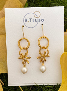 Earrings made with dangling elements of 24kt gold plate over sterling silver circles  and freshwater pearls