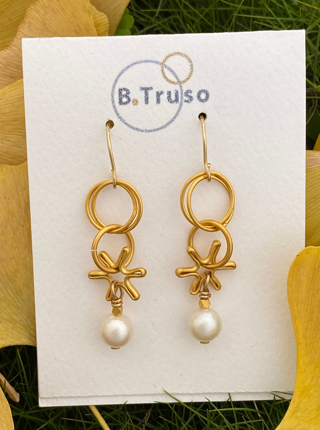 Earrings made with dangling elements of 24kt gold plate over sterling silver circles  and freshwater pearls